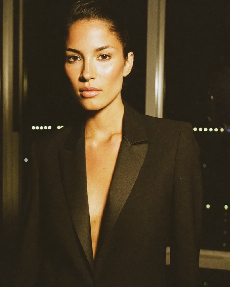 Portrait of a woman in a black tuxedo jacket against a night skyline